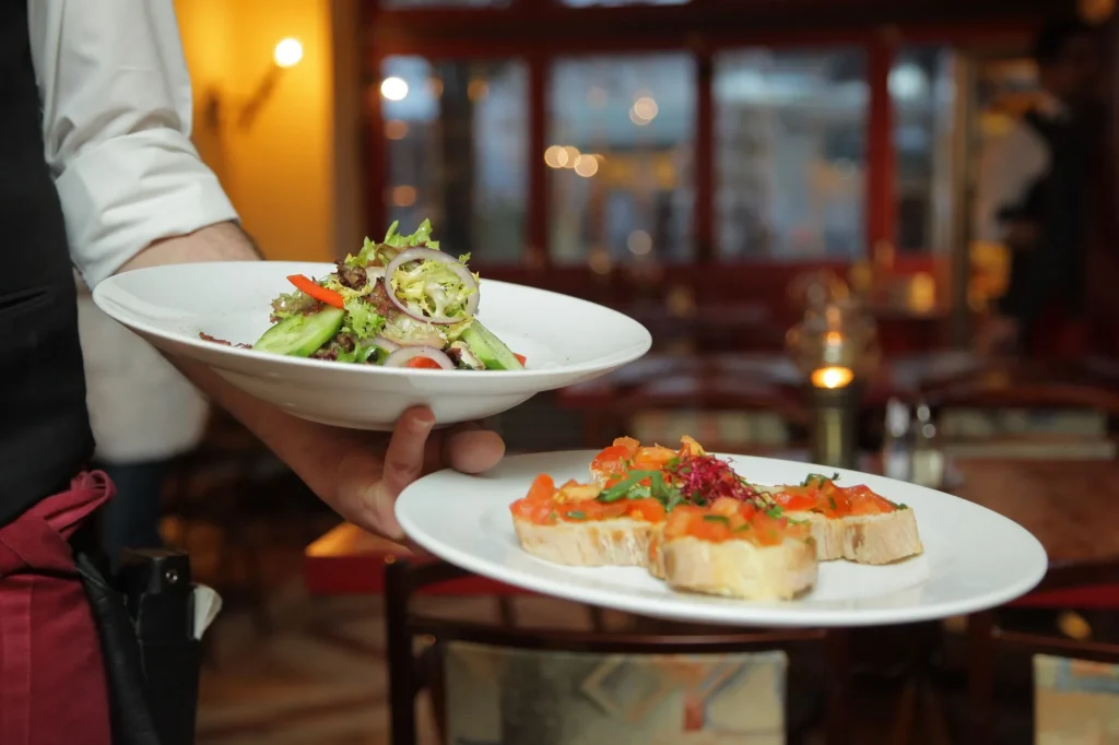 Restaurant server carrying plates to a table