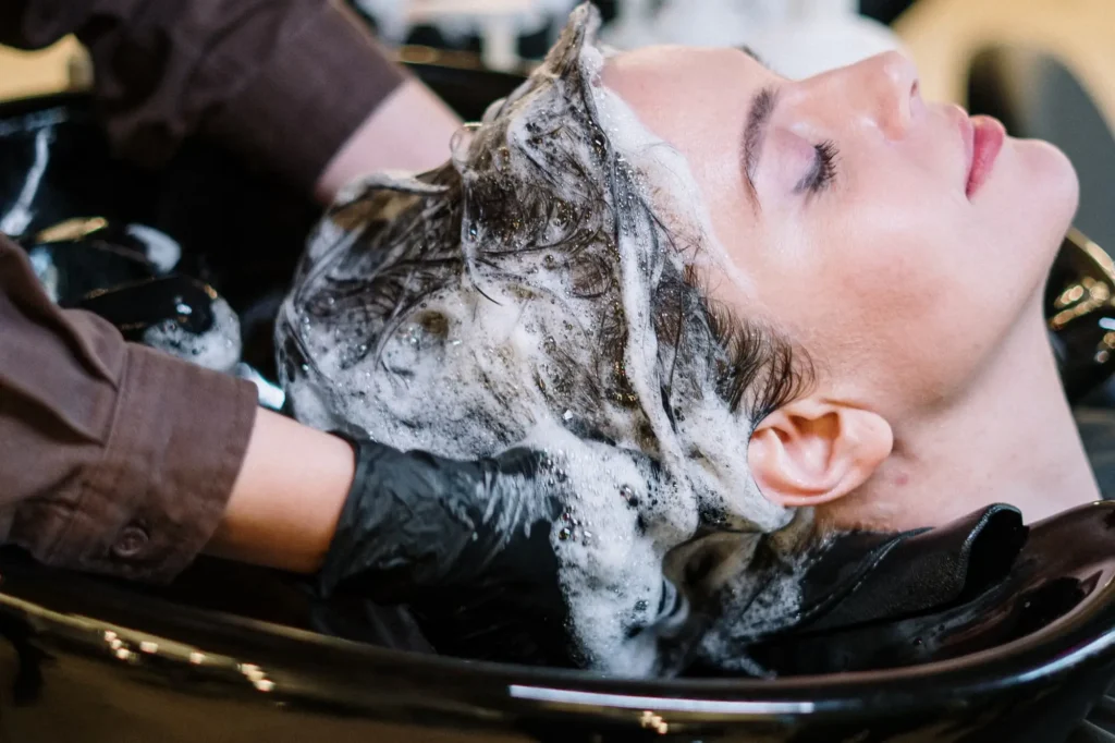 Stylist washing a client's hair at a salon